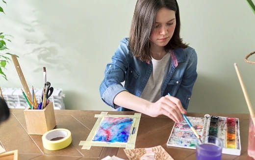 a woman painting on a table
