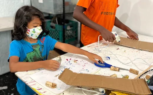 a young girl painting with a paintbrush