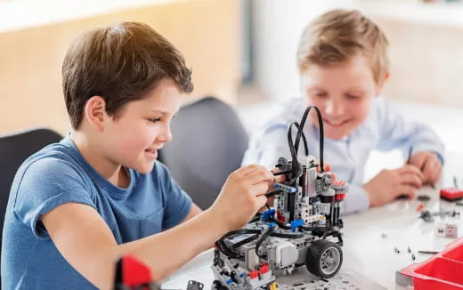 a couple of boys playing with a toy robot