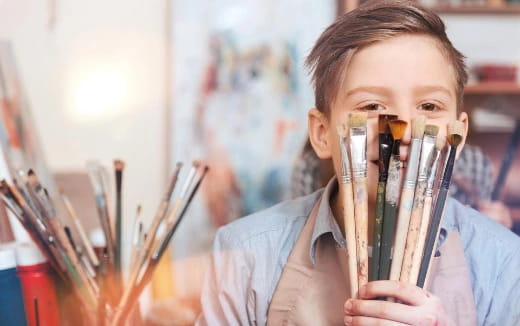 a young boy holding a pencil