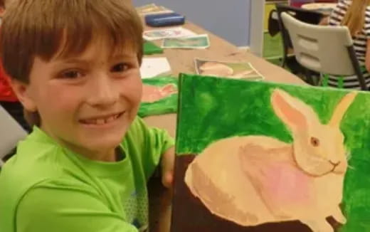 a boy smiling with a paper airplane