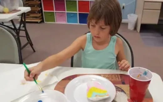 a child painting on a table