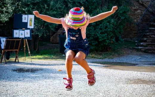 a girl wearing a hat and jumping