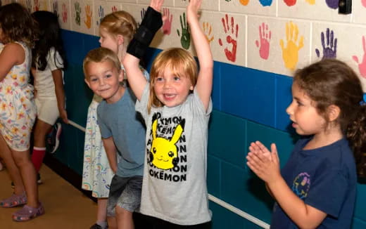 a group of children raising their hands