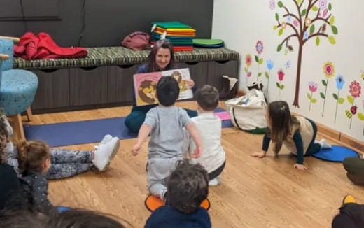 a group of children sitting on the floor in a room