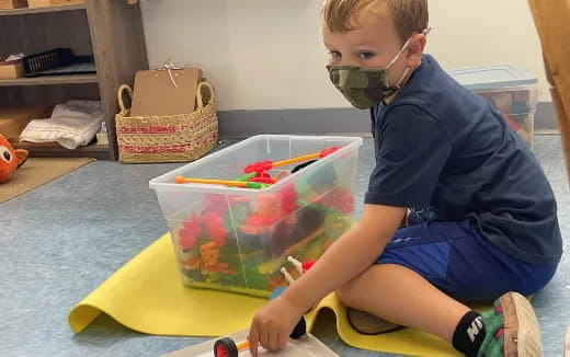 a boy painting on a yellow table