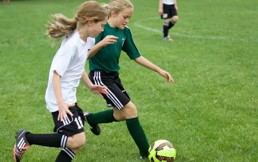 girls playing football on a field