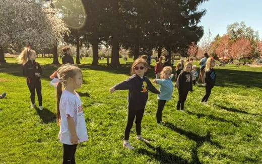 a group of children running in a park
