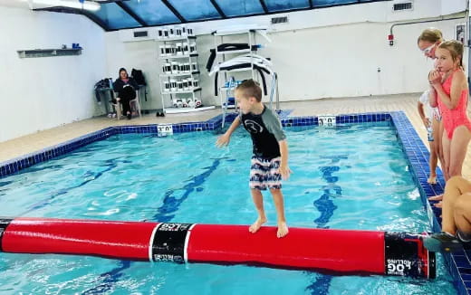 a boy standing on a surfboard
