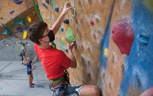 a boy climbing a rock wall