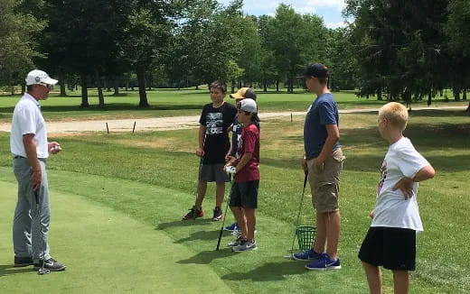 a group of people standing on a golf course