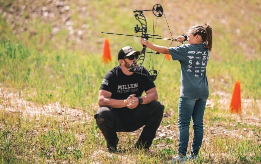 a man shooting a bow and arrow at a woman