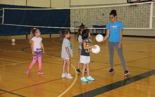 a person and a group of girls playing basketball