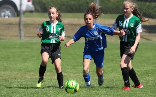 girls playing football on a field