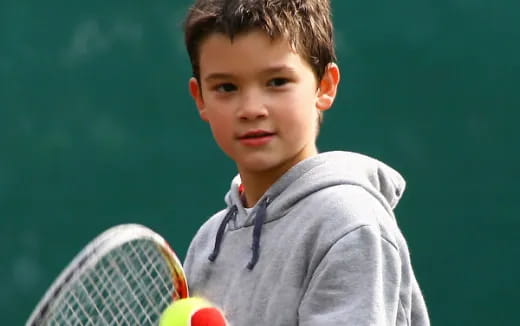 a boy holding a tennis racket
