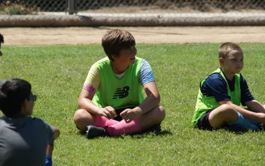 a group of boys sitting on the grass