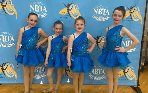 a group of girls in blue dresses
