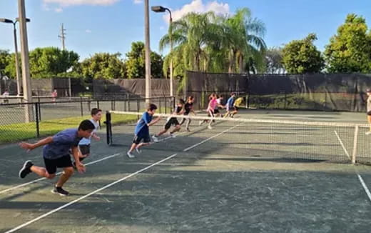 a group of people playing tennis