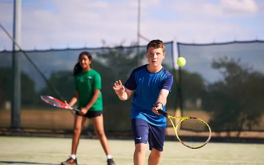 a couple of kids playing tennis