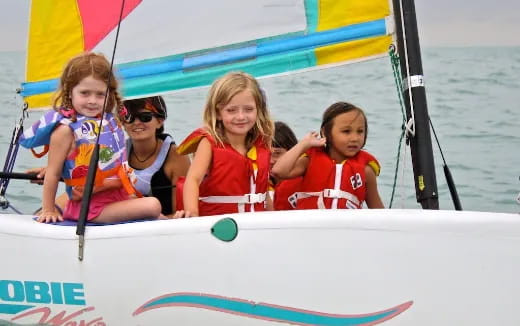 a group of girls in life jackets on a boat