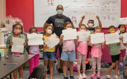 a group of children holding up paper