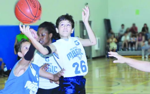 a group of people playing basketball