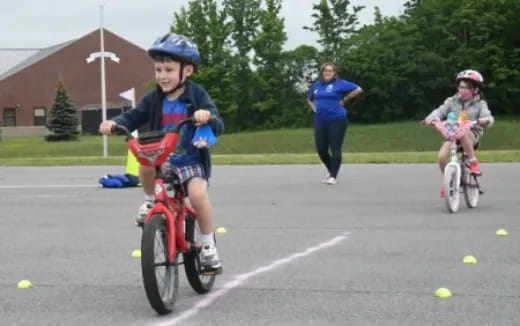 a boy riding a bicycle with a girl on the back