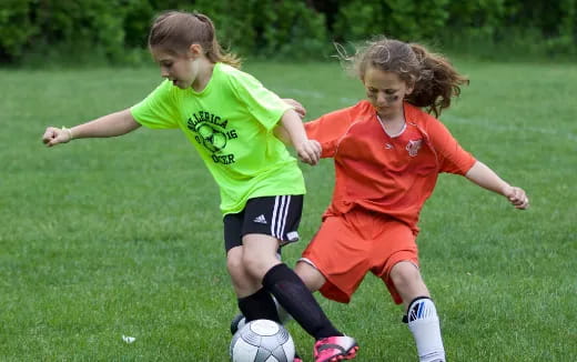 girls playing football on a field
