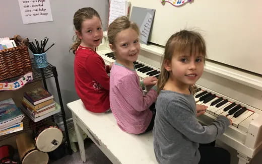 a group of children playing a piano