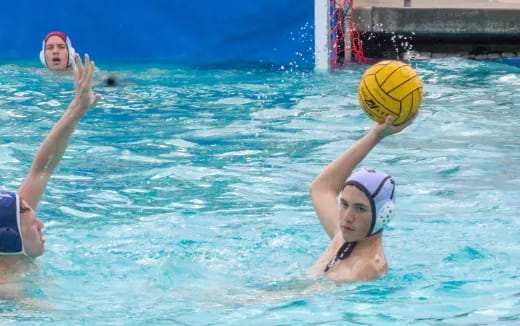 a couple of women playing volleyball in a pool
