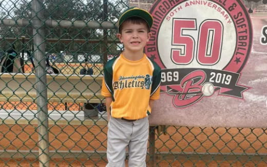 a boy standing behind a fence