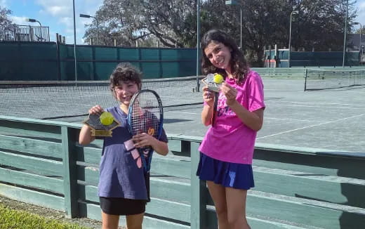 a couple of girls holding tennis rackets