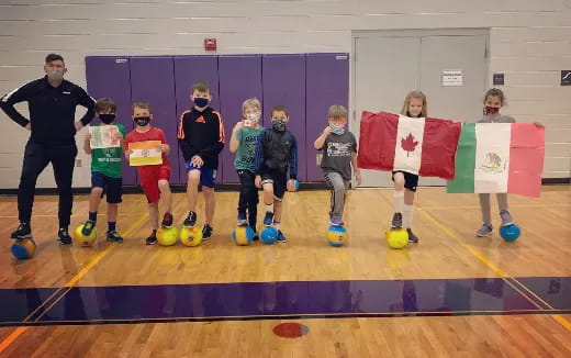 a group of kids posing for a photo with balls