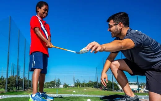 a man hitting a ball with a stick