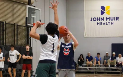 a couple of people playing basketball
