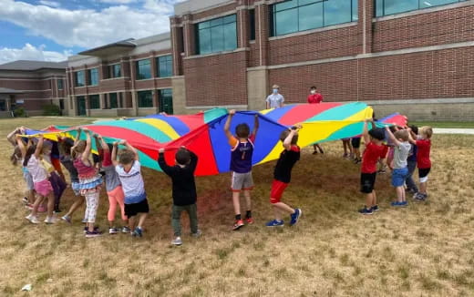 a group of children playing with a kite