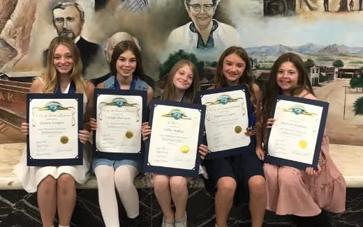 a group of people holding certificates