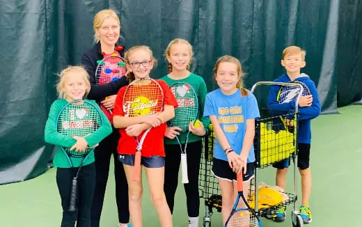 a group of children holding tennis rackets
