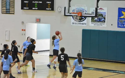 a group of people playing basketball
