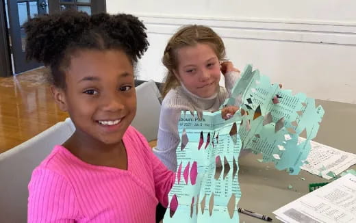 a couple of children holding a piece of paper