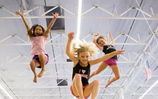 a group of girls jumping in a gym
