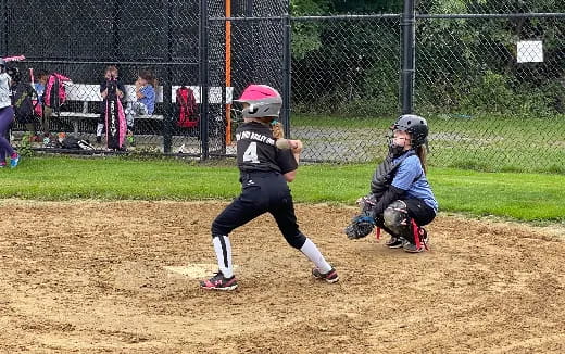 a little league baseball player swings at the ball