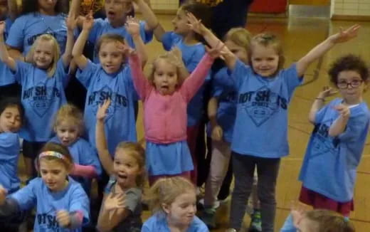 a group of children raising their hands