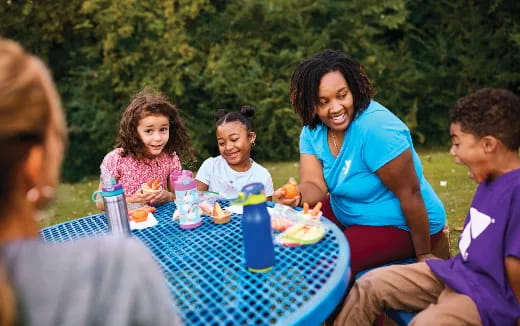 a group of people sitting around a table outside