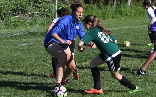 girls playing football on a field