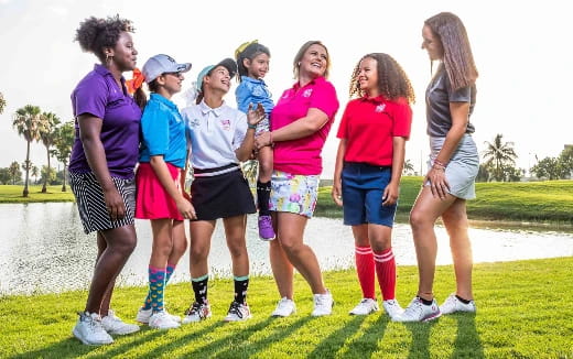 a group of girls standing on a grass field