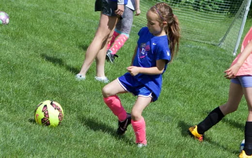 girls playing football on a field