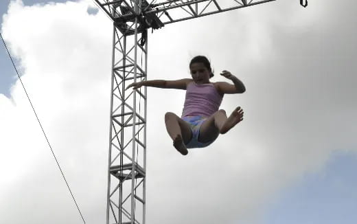 a girl jumping from a zip line