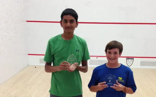 a couple of boys holding a trophy