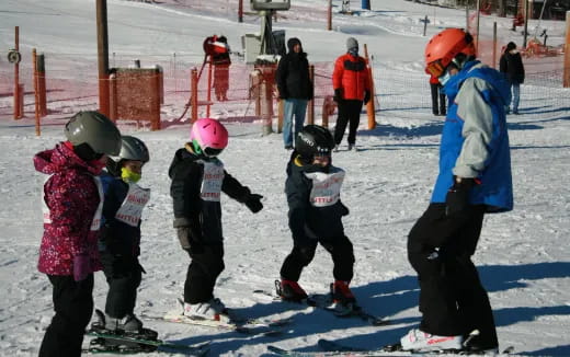 a group of people stand on snow skis
